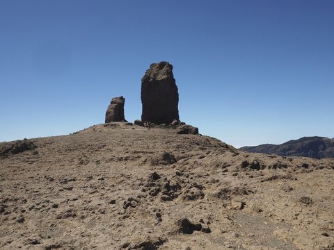 Two large rocks, Roque Nublo on the right, La Rana on the left, rise out of a rocky, barren environment, Roque Nublo, Gran Canaria, Spain