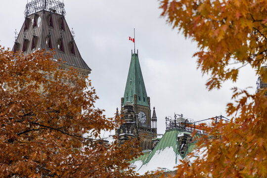 Parliament of Canada with Canadian flag with autumn trees in Ottawa