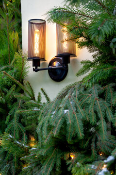 Festive Christmas greenery surrounds glowing lanterns