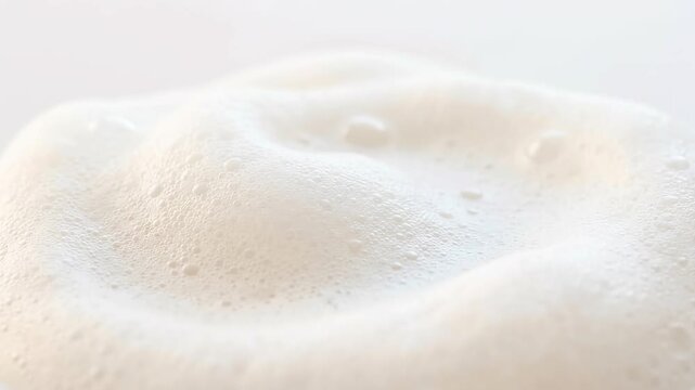 Close up macro shot of white creamy foam texture with small bubbles.