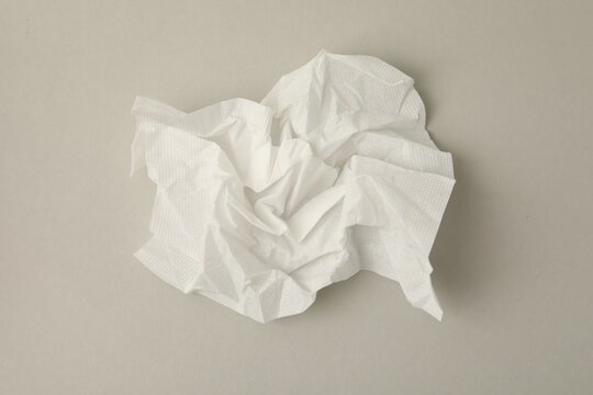 One used paper tissue on light grey background, top view