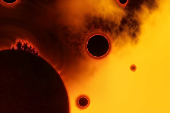 Fiery cosmic display with silhouetted celestial bodies and glowing gaseous formations