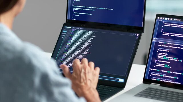 Software Developer Coding On Dual Touchscreen Laptops