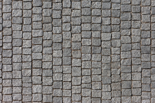 Seamless grey cobblestone pavement pattern background texture of European street granite paving block road surface