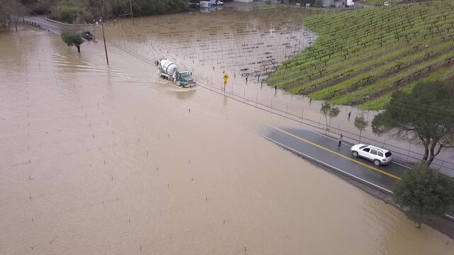 Truck Fords Flooded Westside Road - A large truck carefully passes along Westside Road, flooded by high Russian River water. Sonoma County, California, USA.