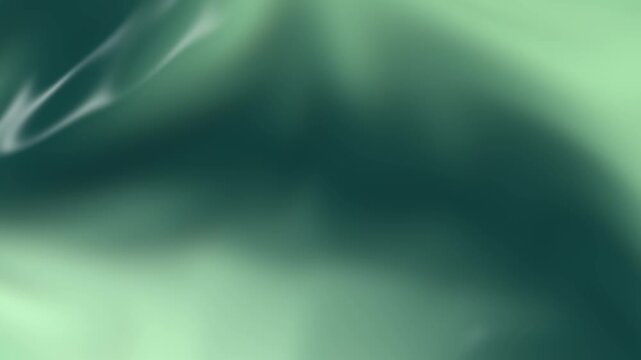 Abstract green liquid silk motion background featuring glowing flowing fabric waves creating smooth elegant futuristic digital animation video clip
