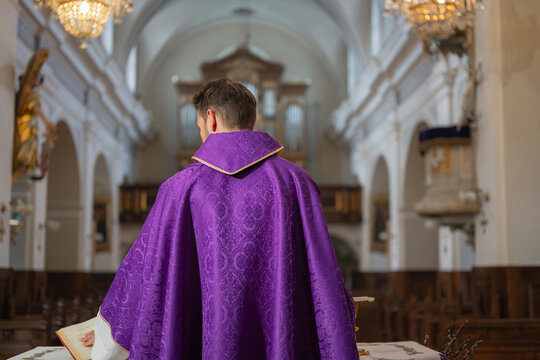 A catholic priest stands at the altar during a eucharistic celebration in a church. The service reflects the christian faith and worship.