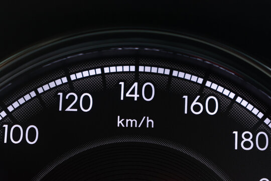 Close-up car speedometer gauge showing speed scale in km/h on dark background