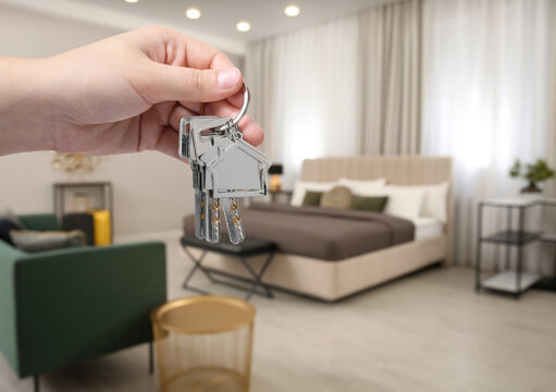 Woman holding keys in apartment, closeup. Rental property