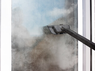Fototapeta premium Window cleaning tool removing moisture from fogged glass in close up view