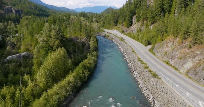 Mountains covered in forest, a river and Sea to Sky Highway between them. Canada