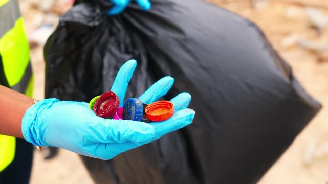 Volunteer showing plastic bottle caps collected during a beach cleanup