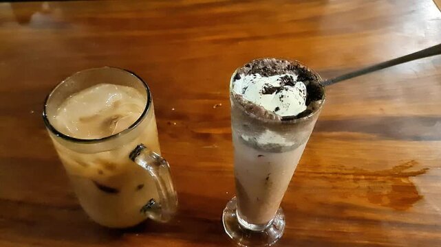 Refreshing Iced Latte and Chocolate Cookies Frappe with Ice Cream Topping on a Rustic Wooden Table