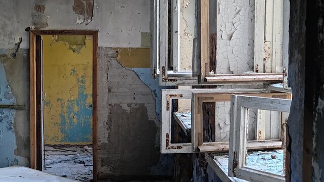 An old door with peeling paint and rusty hinges, set in a rundown building