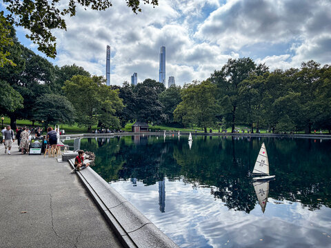 Child watching model sailing boats on the Conservatory Water in Central Park, New York City, United States