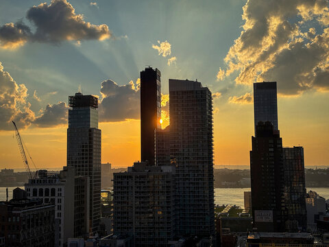 Sun setting behind the towers of Midtown Manhattan seen from a rooftop, New York City, United States