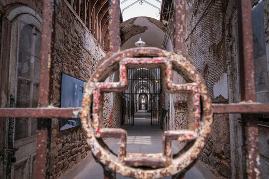 Locking wheel of a cellblock gate in the foreground of a prison corridor at a historic penitentiary, Philadelphia, Pennsylvania