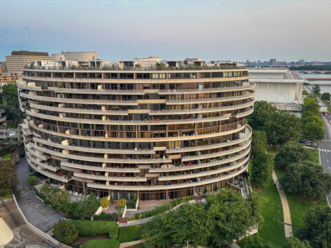 Curved modernist riverside complex at dusk with a performing arts center on the right in Washington, District of Columbia, United States