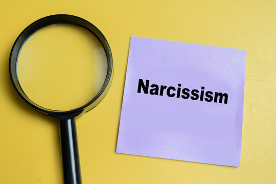 Concept of narcissism write on sticky notes isolated on table.