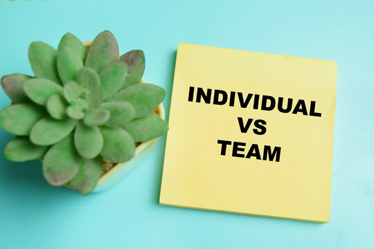 Concept of individual vs team write on sticky notes isolated on table.
