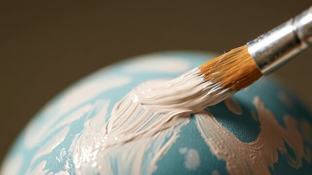 Artist Painting a Folk Pattern on a Pastel Blue Easter Egg