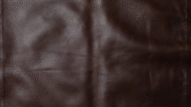Rich dark brown leather texture with visible grain and folds