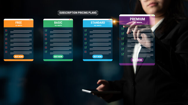 Woman analyzing subscription pricing plans on digital screens with various options such as free, basic, standard, and premium in a modern office setting. Glyphic.