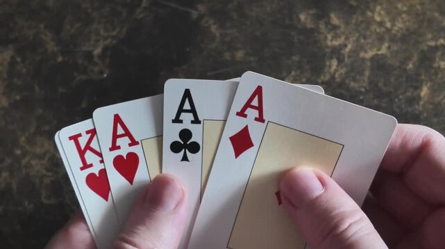 Hands revealing aces and kings playing cards