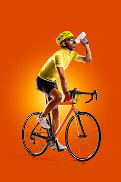 Cyclist. Sports concept. Professional athlete isolated on a orange background. Athlete in action. Sport