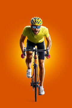 Cyclist. Sports concept. Professional athlete isolated on a orange background. Athlete in action. Sport
