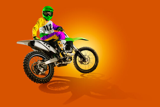 Motocross. Sports concept. Professional athlete against an orange background. Athlete in action. Sport.