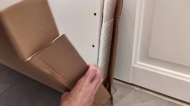 Female hands carefully close a cardboard furniture box, securing the packaging for storage or transport, household task, horizontal video.
