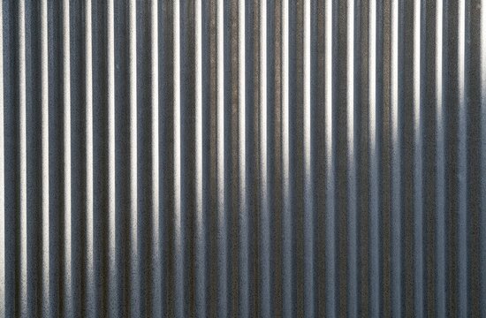 Corrugated metallic surface with vertical ridges and highlights