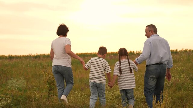 Happy family girl boy mother father walking field , Parents and children enjoying sunset together, Family girl boy mother father bonding outdoors, Family time nature, Togetherness love countryside