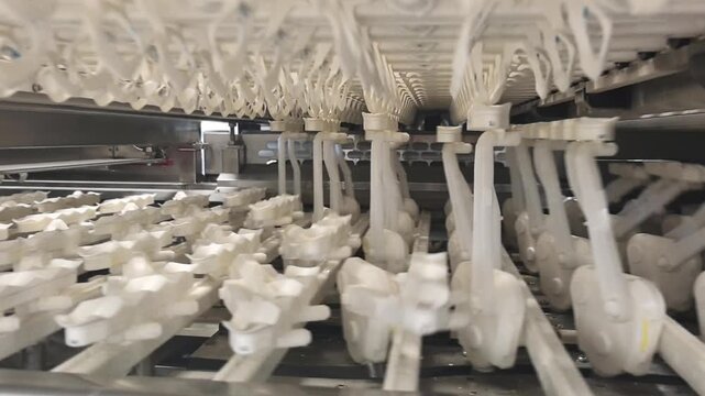 Robotic arms for sorting chicken eggs move efficiently along the production line. The machines perform various tasks, demonstrating how automation aids manufacturing. This setup showcases advanced 