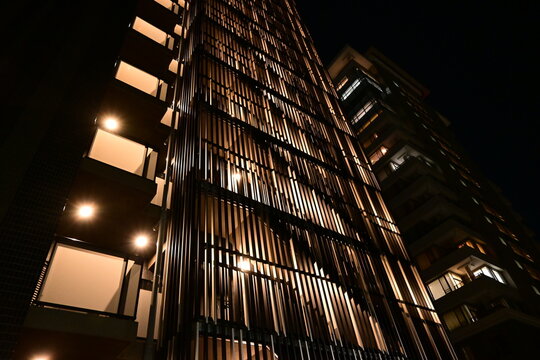 夜の街に輝く近代的な高層マンションの低角度撮影