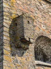 Weathered stone fortress facade with projecting defensive masonry. © Trygve