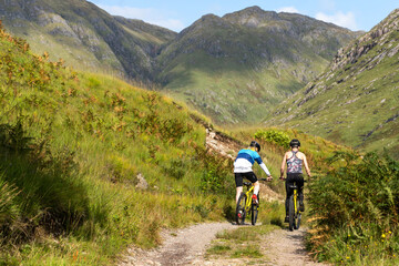Fototapeta premium Cyclists exploring scenic mountain trail.