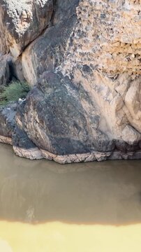 Ancient broken stone dam in a rocky river gorge in Saudi Arabia.