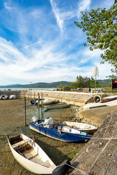 Stranded boats sit on the exposed lakebed at Lake Trasimeno, documenting the receding shoreline and significant decline in water level.
