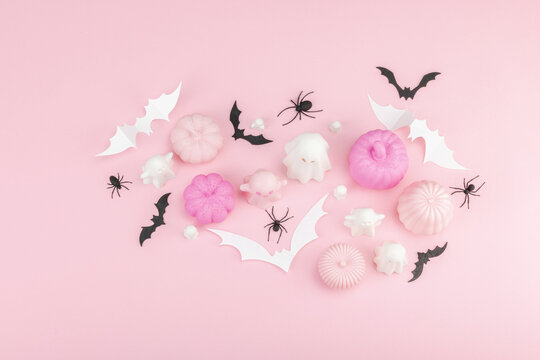 Pink Halloween flat lay with pastel pumpkins, cute ghosts, paper bats, and black spiders