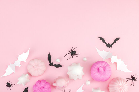 Pink Halloween flat lay with pastel pumpkins, cute ghosts, paper bats, and black spiders