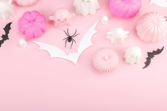 Pink Halloween flat lay with pastel pumpkins, cute ghosts, paper bats, and black spiders