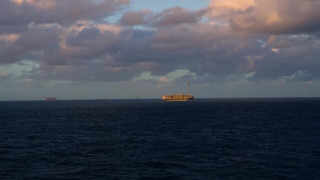 Offshore oil field with multiple FPSOs, oil platforms, and vessels operating at sea. Oil and Gas Industry.