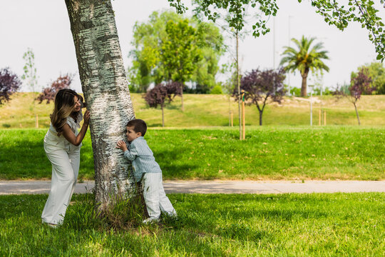 Mother and son playing hide and seek in park