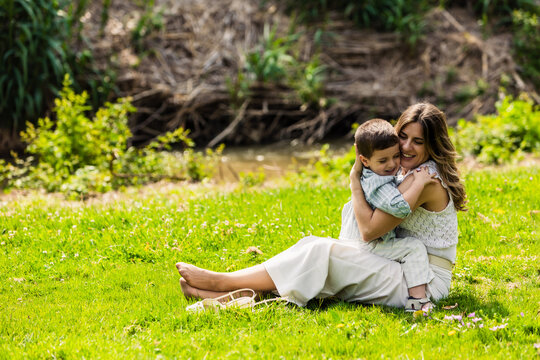 Mother and young son embracing, showing in nature