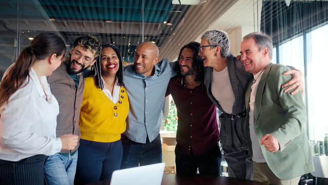 Professional team celebrating successful project milestone, sharing joyful moment of unity and laughing together in modern office workspace, highlighting collaborative workplace achievement