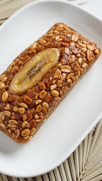 Gourmet Malagasy Koba Akondro Caramelized Banana Peanut Loaf on White Ceramic with Copy Space