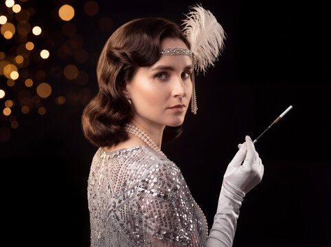 Vintage 1920s woman in silver sequined dress and feather headpiece