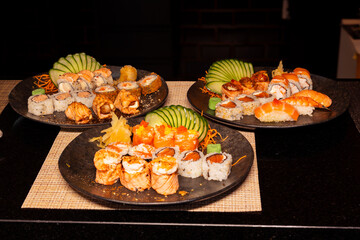 Refeição de sushi com vista zenital em mesa escura com espaço para texto © Matheus